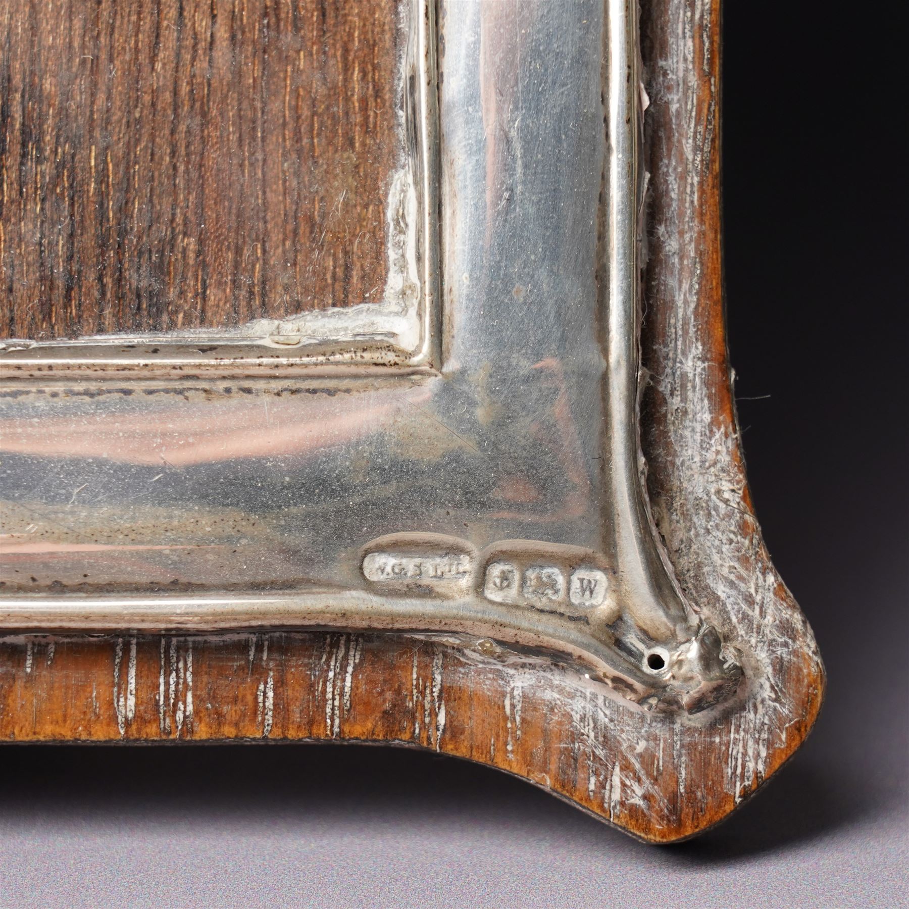 Embossed silver photograph frame London 1985 aperture 12.5cm x 8.5cm, another with scroll top Birmingham 1921 13cm x 9cm and a circular frame Birmingham 1909 6cm