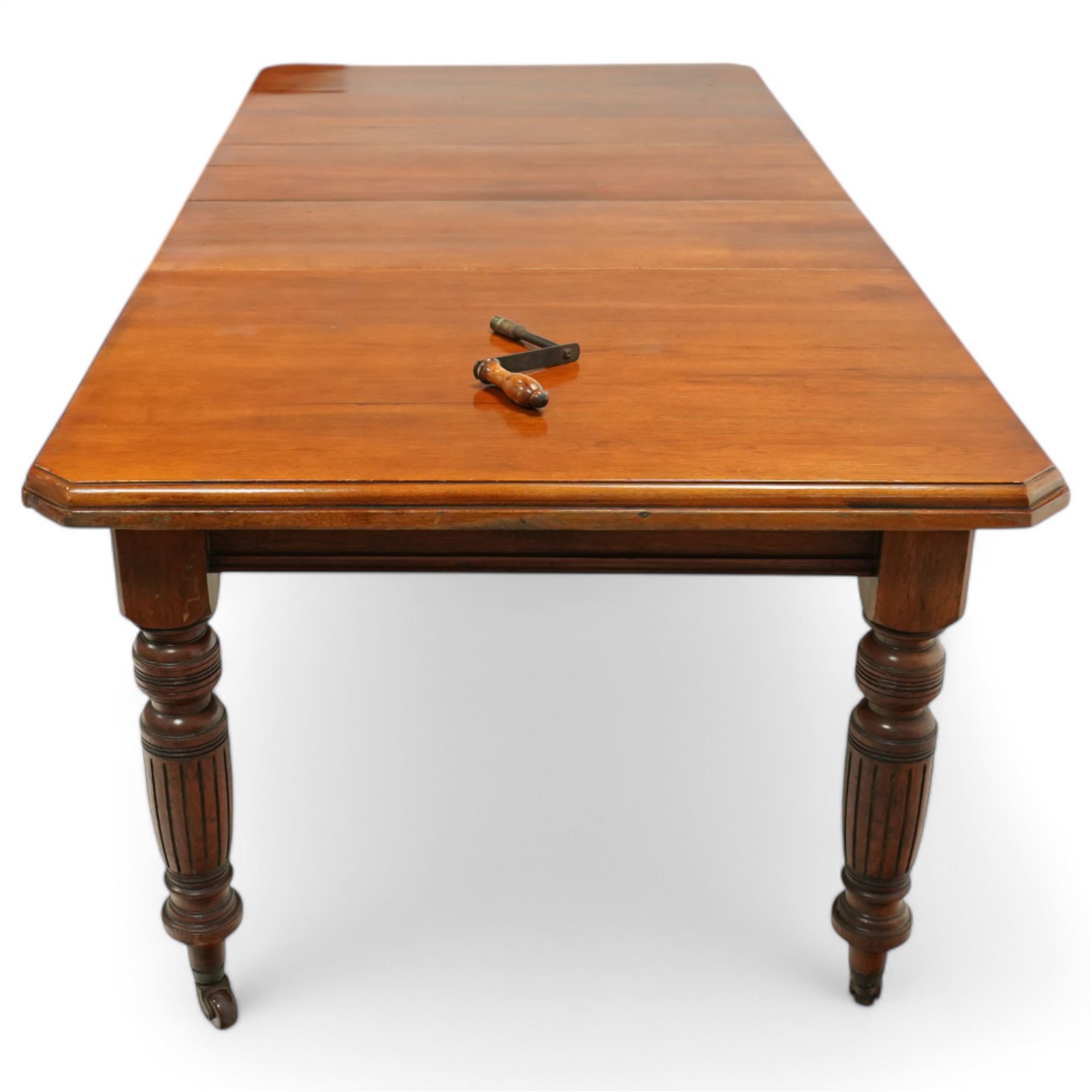 Late Victorian mahogany extending dining table with two leaves, moulded chamfered edge above, turned and reeded legs and ceramic castors, winding handle included, 205cm extended, 132cm closed, 102cm wide, 73cm high
