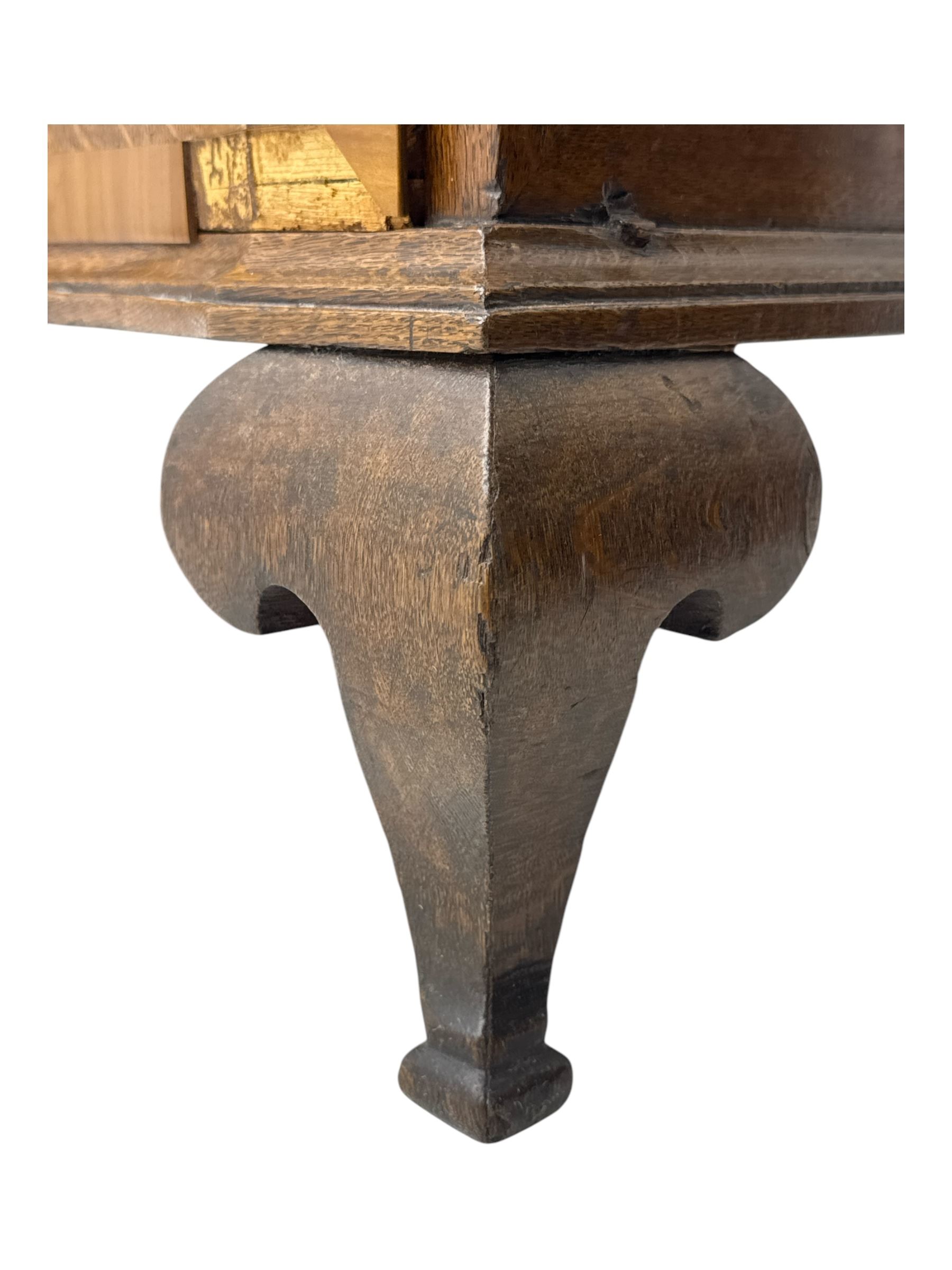 Late 19th century continental oak commode, serpentine fronted with parquetry and crossbanded decoration, the raised superstructure back fitted with a central bank of five recessed drawers flanked by concave drawers, above three full-width drawers with brass ring handles, raised on cabriole supports