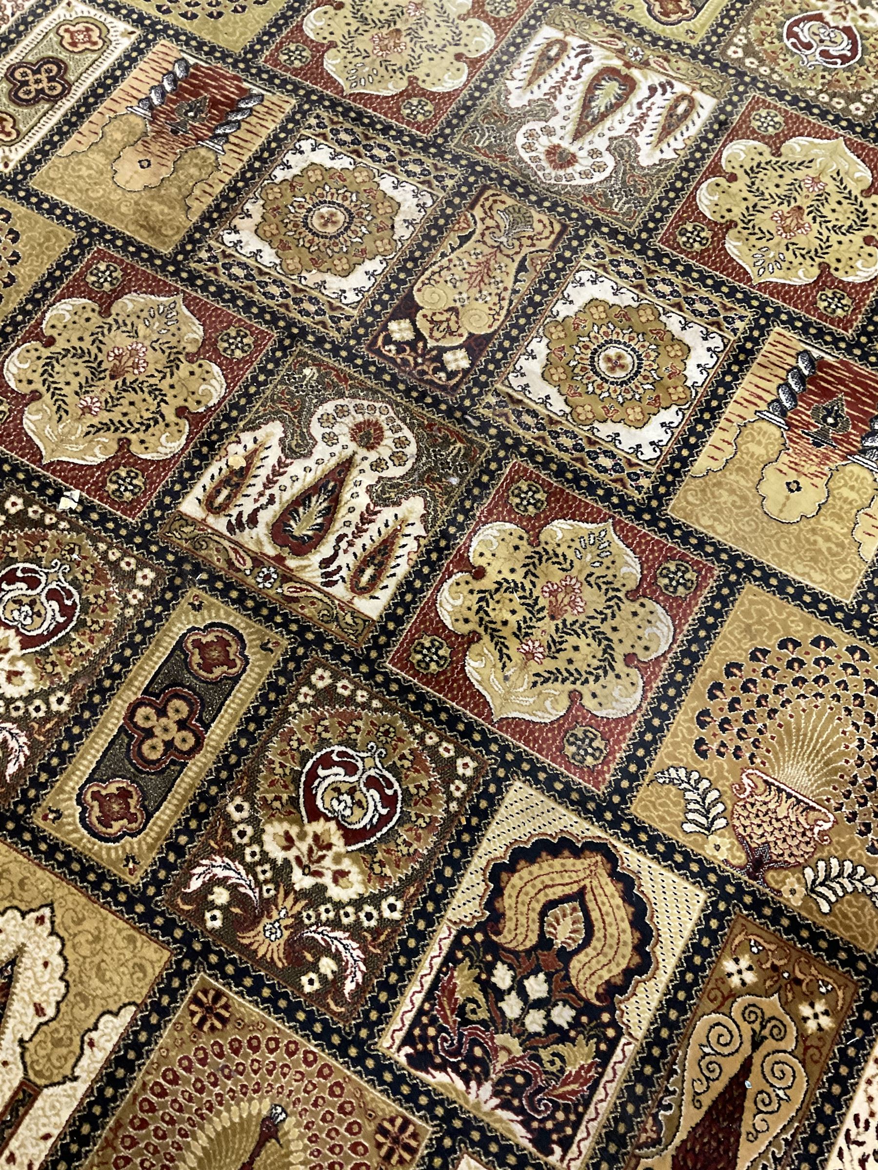 Persian design carpet, the field with various size tiles decorated with stylised plant motifs, floral urns and peacocks, the main border decorated with repeating foliate motifs and trailing flower heads
