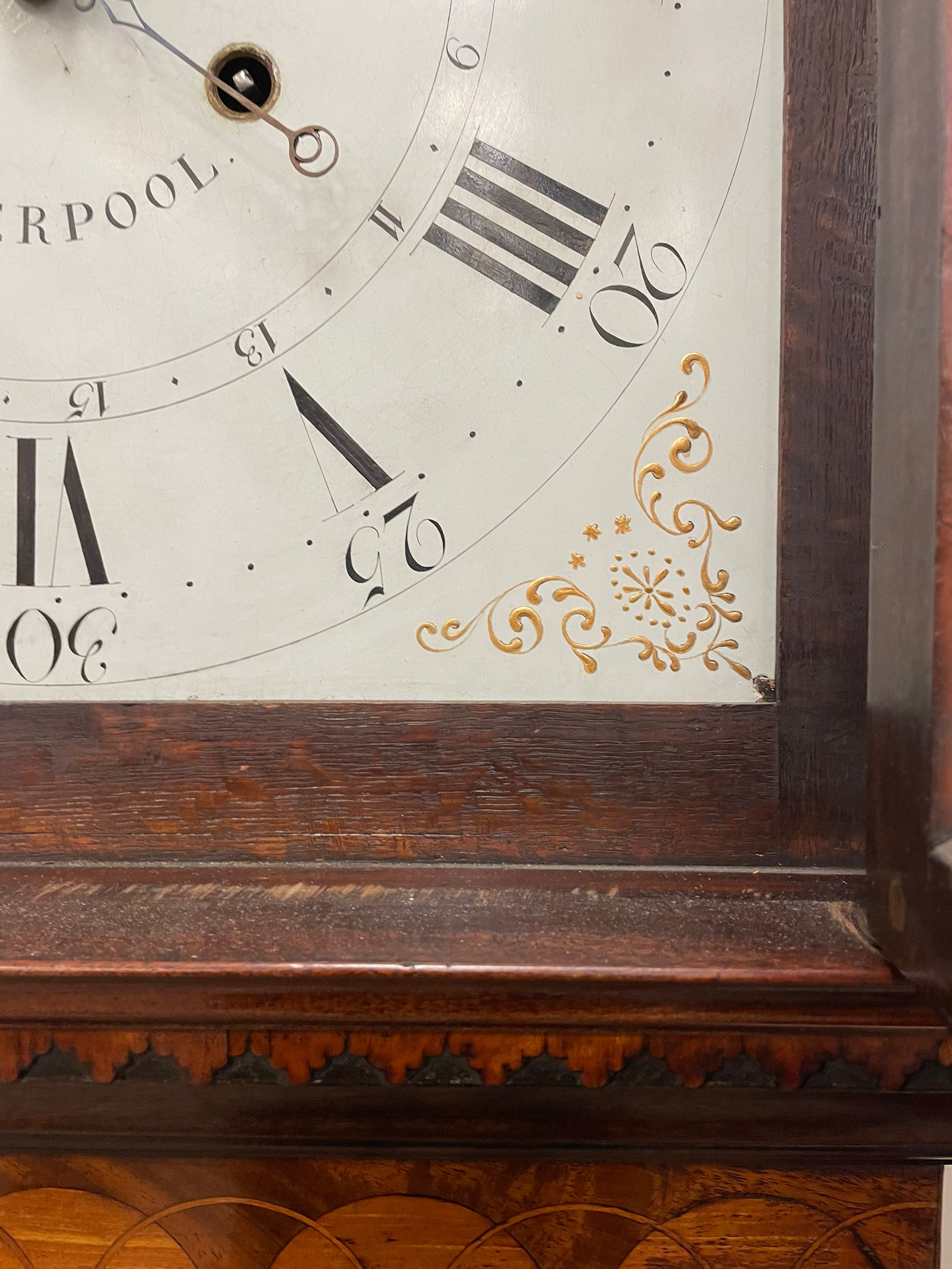 Penlington of Liverpool – early 19th century 8-day mahogany longcase clock, swans neck pediment with three turned wooden finials and verre eglomise panels, trunk with reeded columns and wavy topped door, plinth with canted corners on bracket feet, painted break-arch dial with Roman numerals and five-minute Arabic’s, centre sweep calendar and seconds hands, blue steel serpentine hands, signed beneath a painted rolling moon in the arch PENLINGTON, LIVERPOOL, eight day four pillar movement, anchor escapement and rack striking on a bell. With pendulum and weights.  The Penlington family were prolific clockmakers in 19th century Liverpool working from several addresses in the city, also recorded as chronometer and chronograph makers.