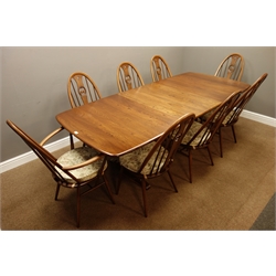  Ercol golden dawn finish elm dining table with three additional leaves (101cm x 162cm - 255cm (with leaves)), and eight stick and hoop chairs with swan spats  