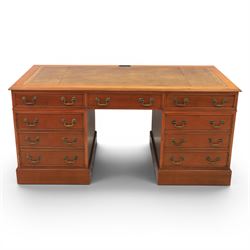 Georgian design yew wood twin pedestal office desk, the top featuring an inset leather writing surface, with drawer drawers and centre keyboard slide, all above two cupboards with slide out shelves