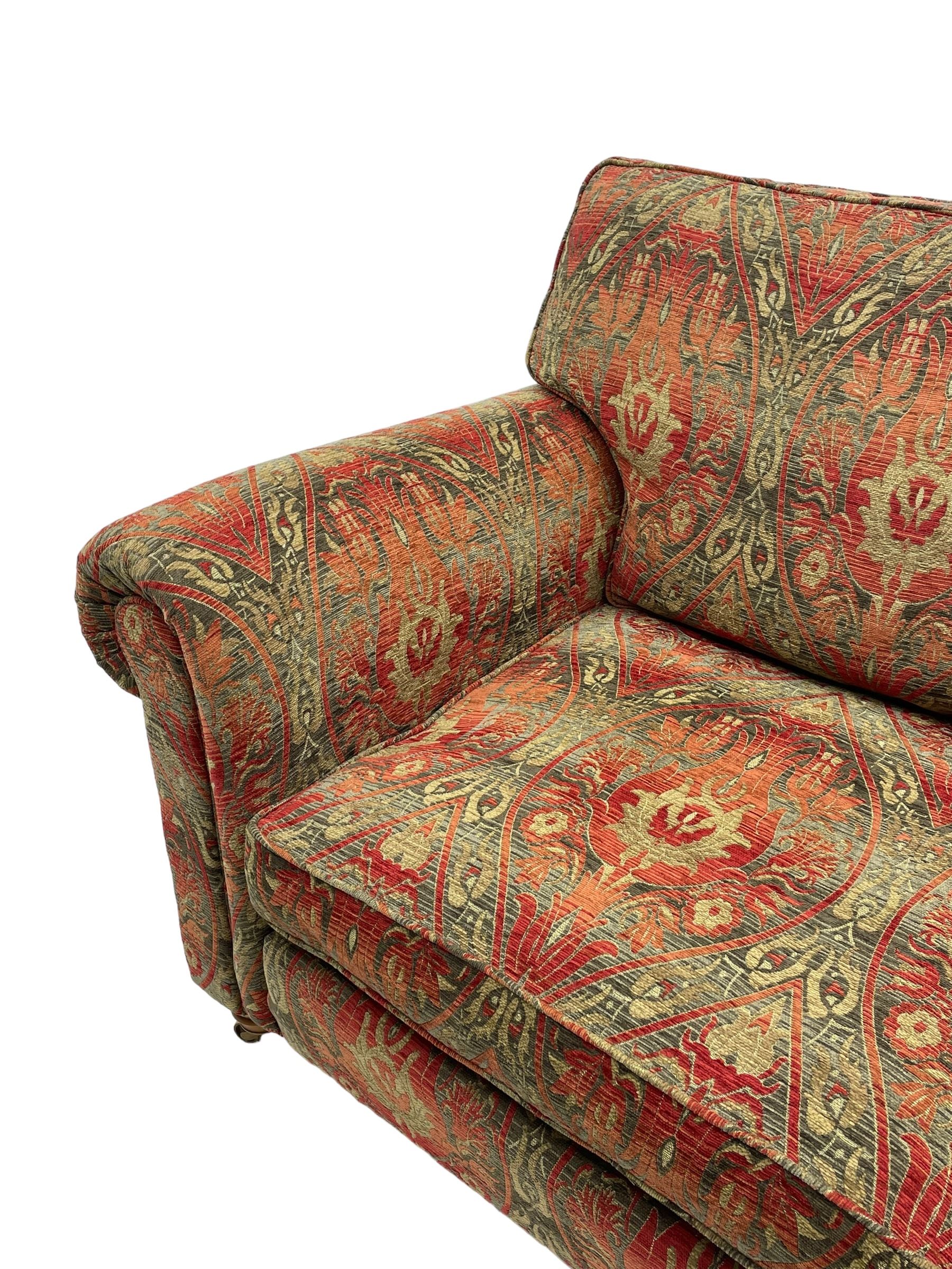 Duresta - 'Beaminster' grande two-seat sofa, traditional shape with rolled arms, upholstered in 'Althorp' russet and stone floral pattern fabric, on turned feet with brass castors
