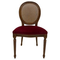 Set six French style walnut finish dining chairs, oval cane bergere backs over serpentine seats upholstered in red, flower head carved fluted supports