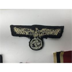 WWII German Iron Cross 2nd Class, the suspension ring stamped 128 for S. Jablonski G.m.b.H. Posen; with ribbon; together with an embroidered cloth eagle badge and quantity of German medal ribbons.