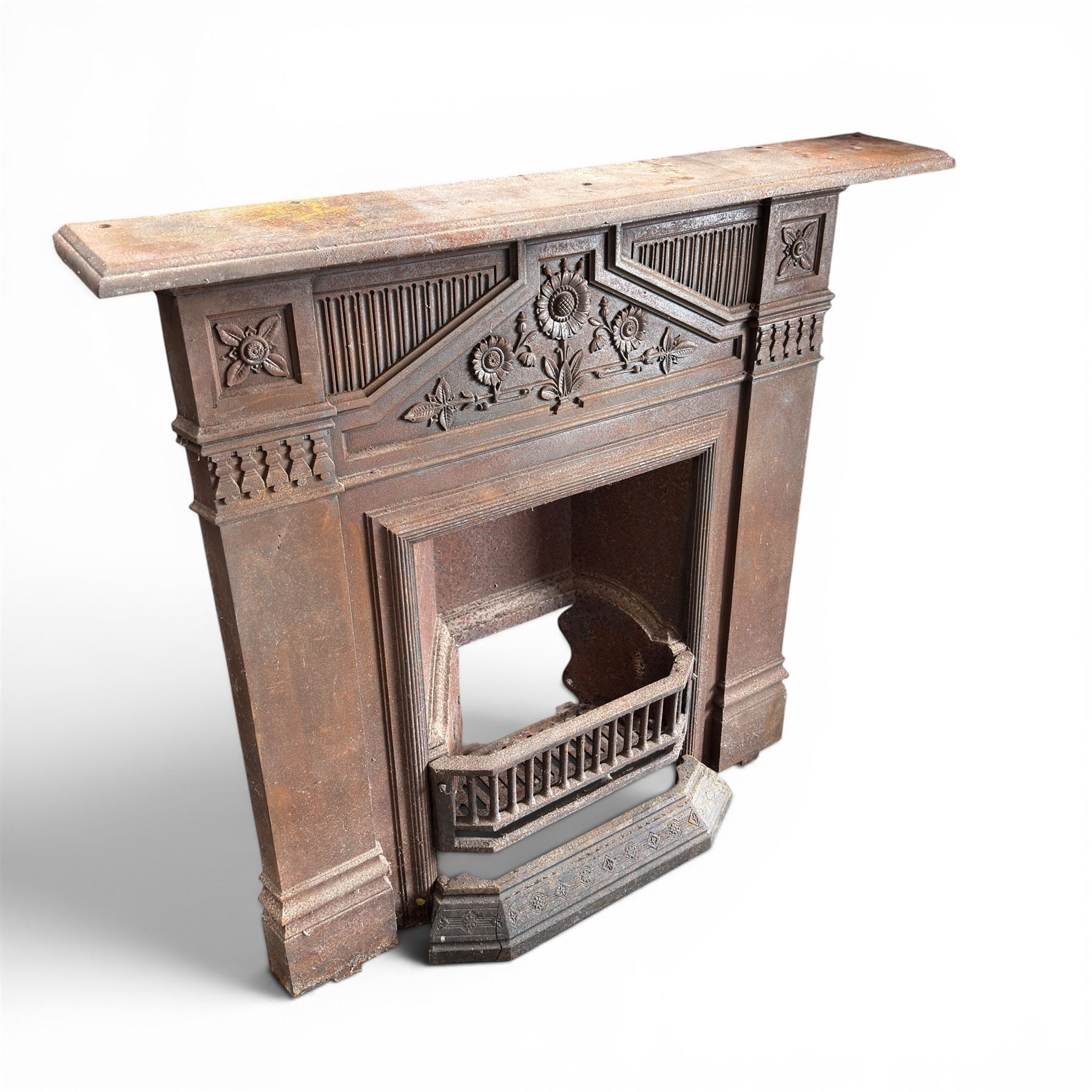 Late Victorian cast ion bedroom fireplace, decorated with floral poppy motifs and flluting