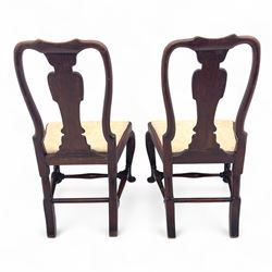 Pair of early 18th century walnut side chairs, vase-shaped splats beneath shaped top rails, drop-in seats upholstered in floral damask, on cabriole front legs terminating in pad feet, united by turned stretchers