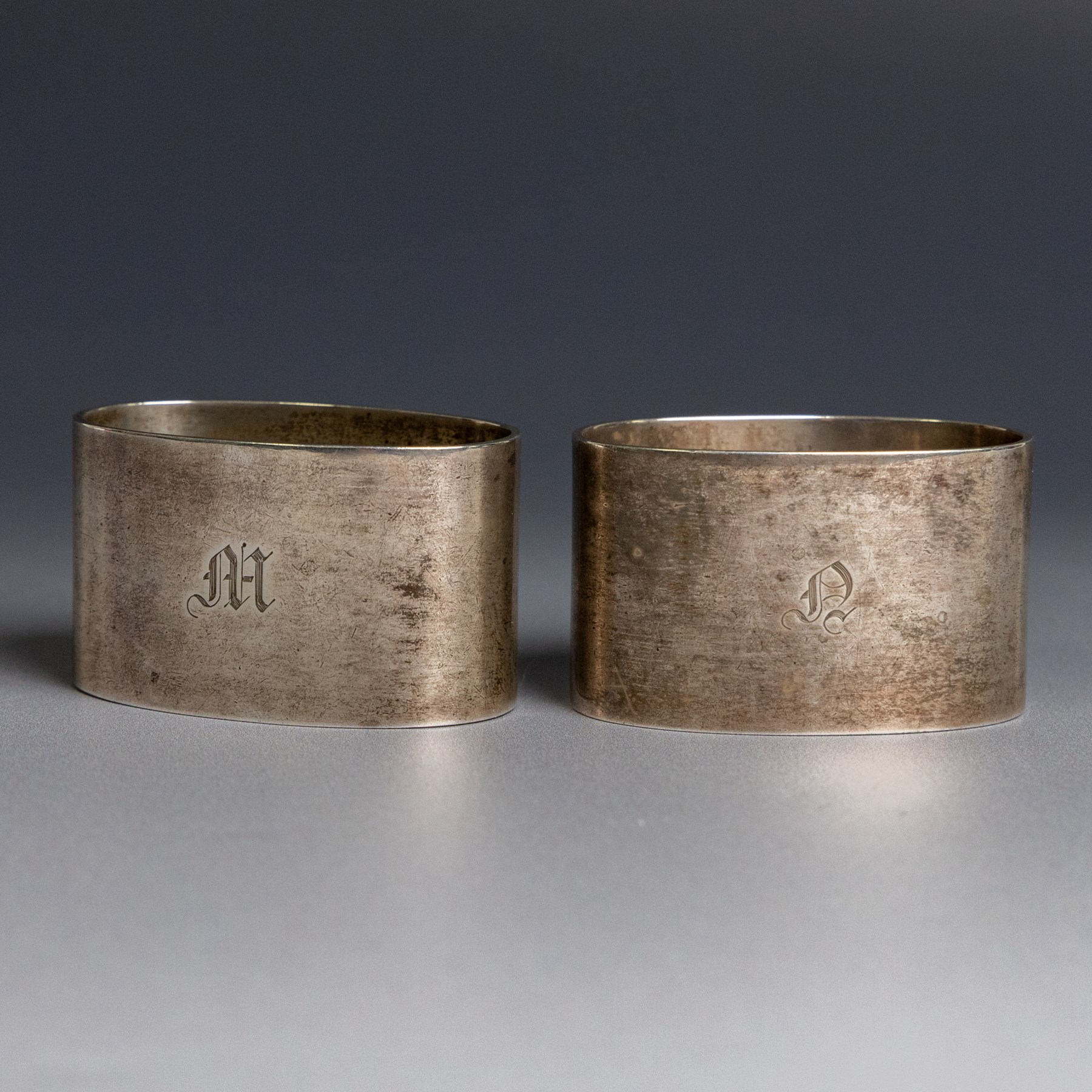 Two silver napkin rings, of oval form with engraved initials, both hallmarked