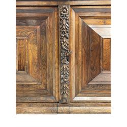 Late 17th century Flemish/Dutch rosewood and oak ‘Zeeuwse Kast’ or cupboard, projecting cornice carved with three putti masks, the uprights carved with lion masks over ribbons, flower heads and foliage, enclosed by four geometric panelled doors, lower central upright carved with flower head over foliate ribbon with bird among foliage, the escutcheon hidden by swivel berry carved cover, interior fitted with shelves, two drawers and shallow hinged cupboard, on two large turned and ebonised feet, circa 1680