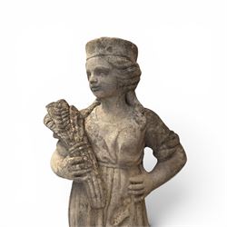 Lucas Stone - pair of cast stone garden figures, modelled as young female figures holding wheat sheafs and baskets of flowers, each on square bases, weathered finish, makers mark stamped to base