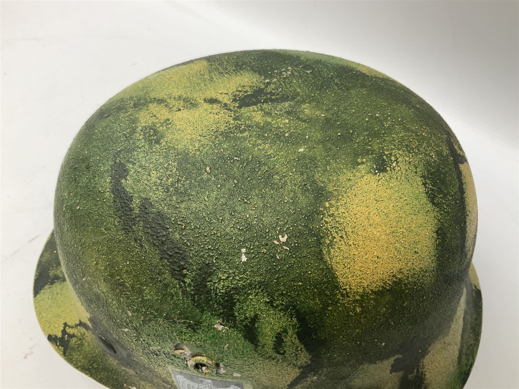 Fully restored German steel helmet, the camouflage painted exterior with two decals and replacement leather liner