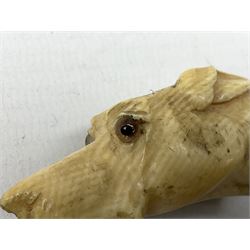 19th century carved ivory walking cane handle, modelled as the head of a greyhound with inset glass eyes, together with a further 19th century ivory example, modelled as a caricature of a gentleman's head, (2)