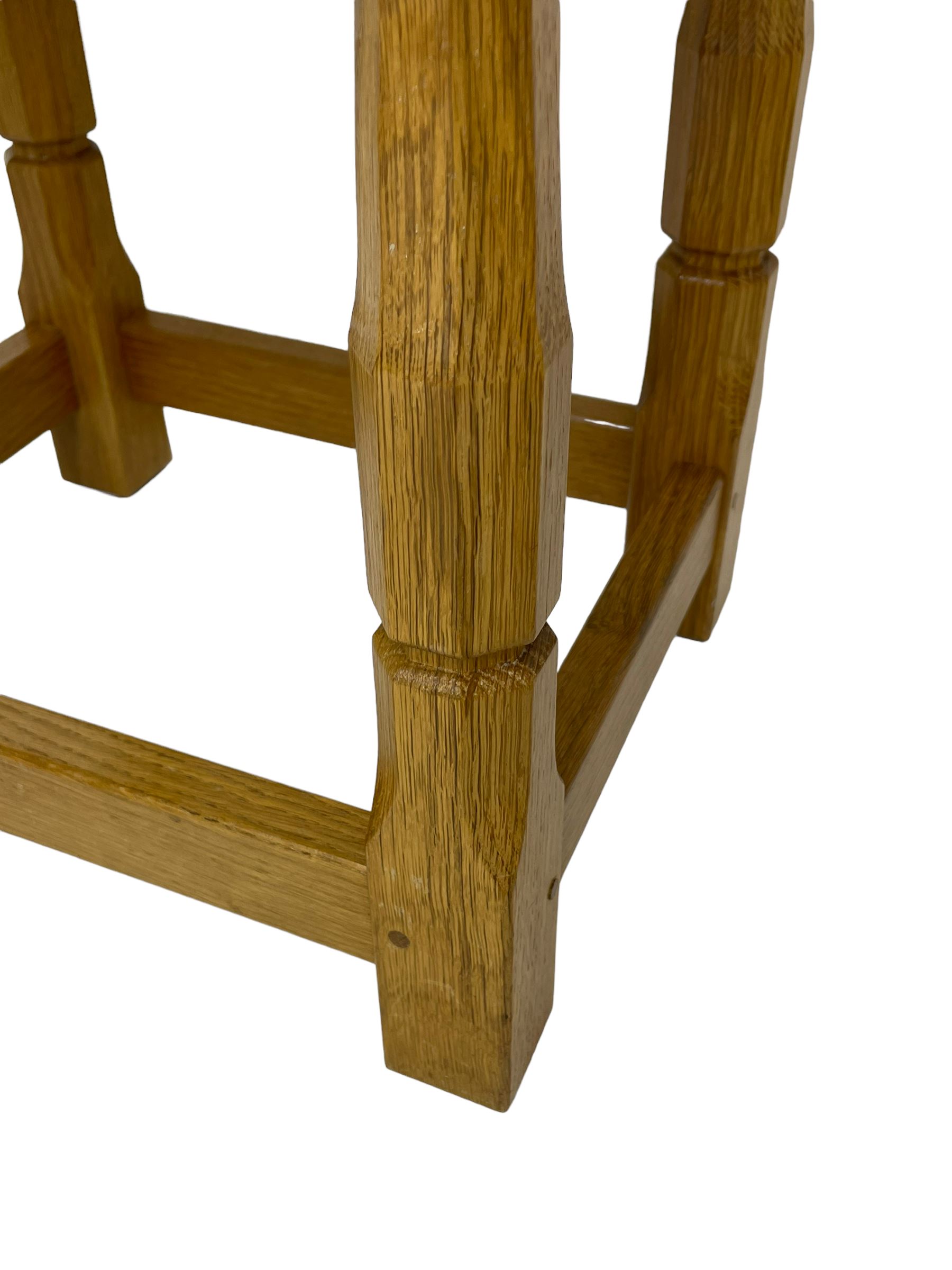 Brian Haw (former Mouseman carver) - Yorkshire oak stool, blue leather upholstered seat with stud band, on octagonal supports joined by plain stretchers