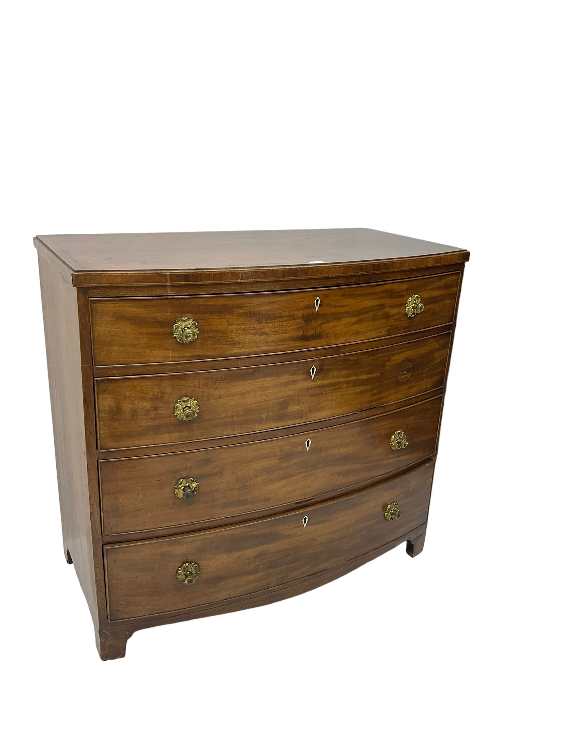 Regency mahogany bow front chest, the top with ebony and satinwood stringing, fitted with four cockbeaded drawers with brass pull handles and bone escutcheons, on bracket feet