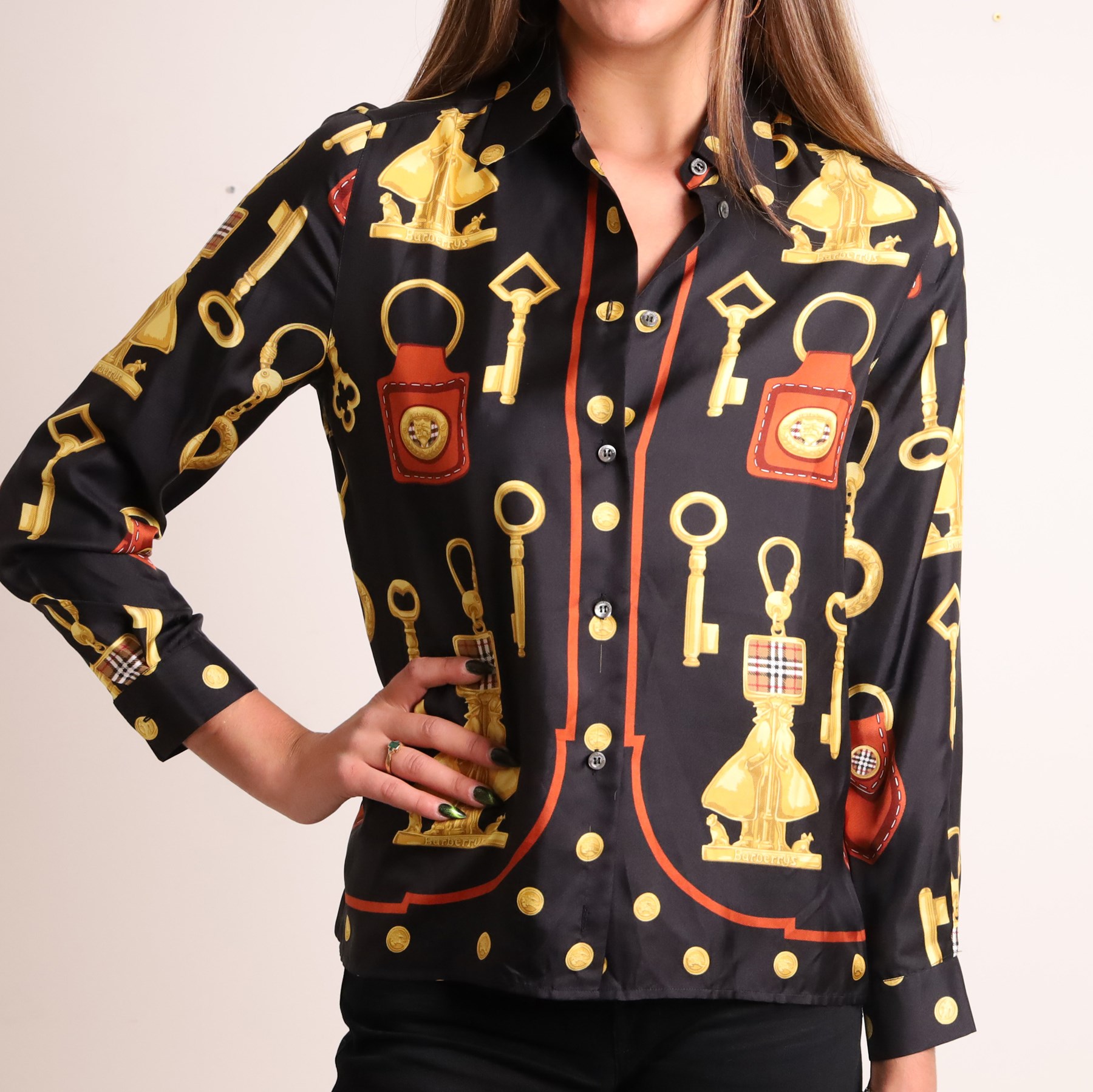 Burberrys – navy wool blazer and silk shirt, the blazer made in England, with gilt Burberry buttons, embroidered monogrammed breast pocket, black lining with Burberry motif and branded sleeve label, size S/M; the blouse in black 100% silk with all-over novelty print of keys, padlocks, coins and Burberry check motifs in yellow, orange and red, size S, made in Italy (2)
