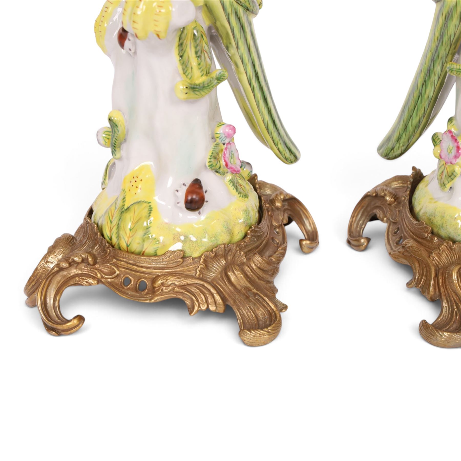 Pair of candlesticks, modelled as green parrot upon a flowering branch, upon four gilt acanthus leaf feet, H36cm