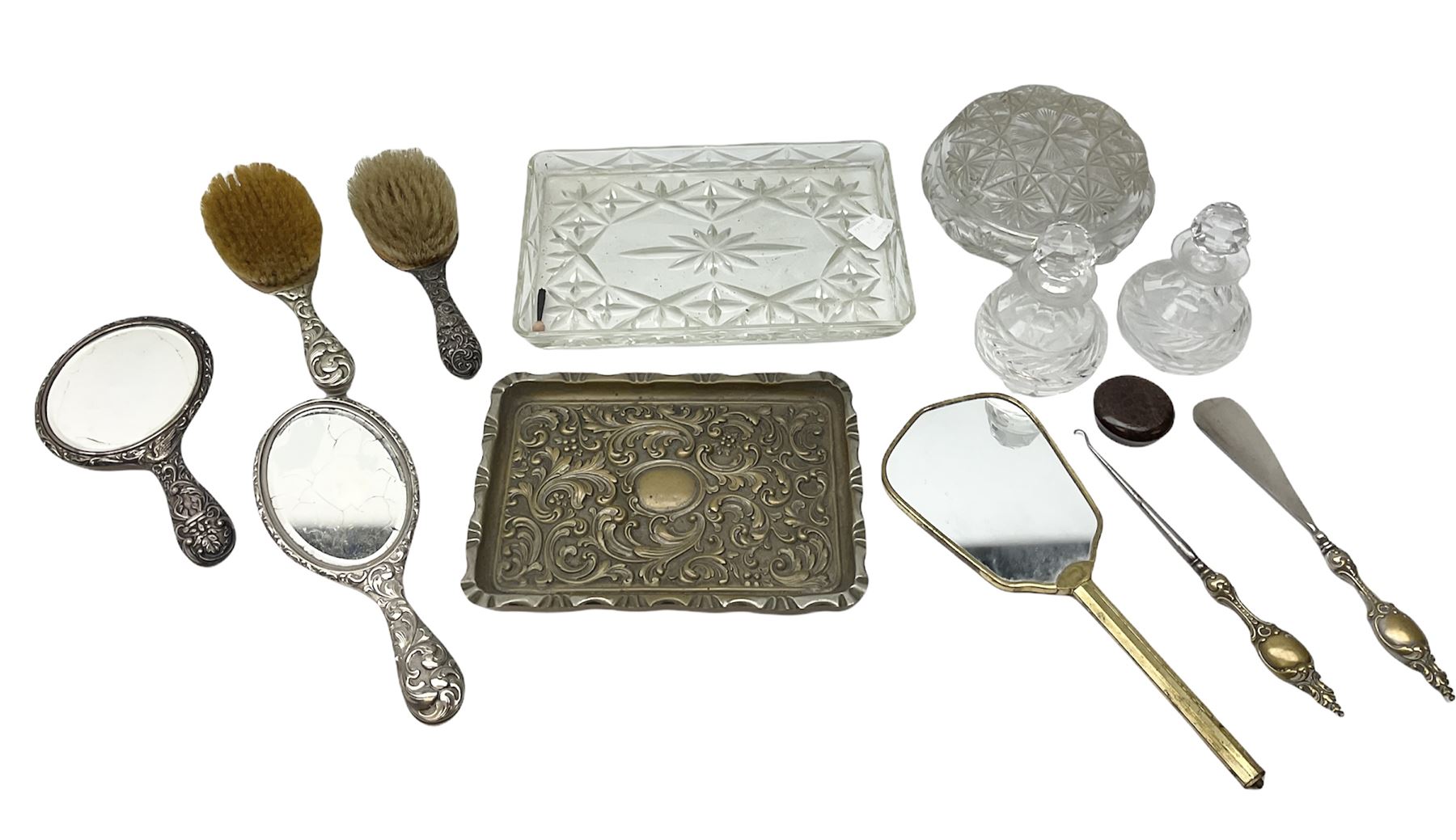 Glass dressing table tray, scent bottles and lidded bowl, metal mounted foliate design hair brushes and handheld mirrors etc