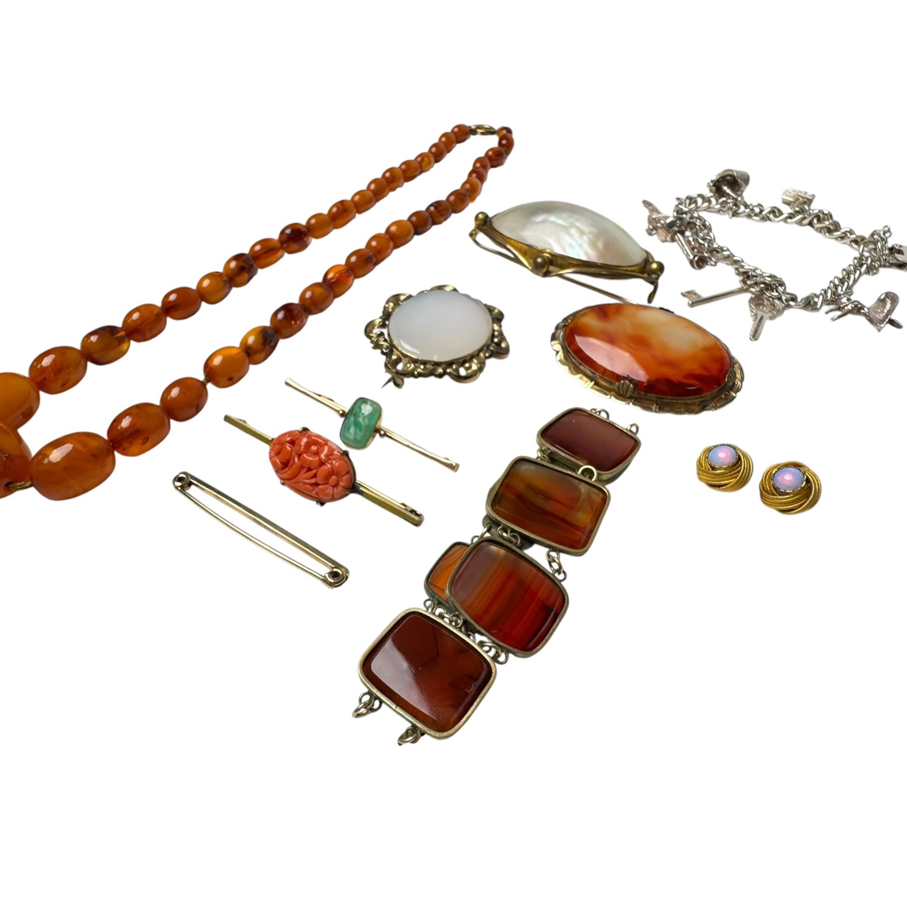 Three 9ct gold brooches, including two stone set examples, silver charm bracelet, amber type beads and gilt metal jewellery