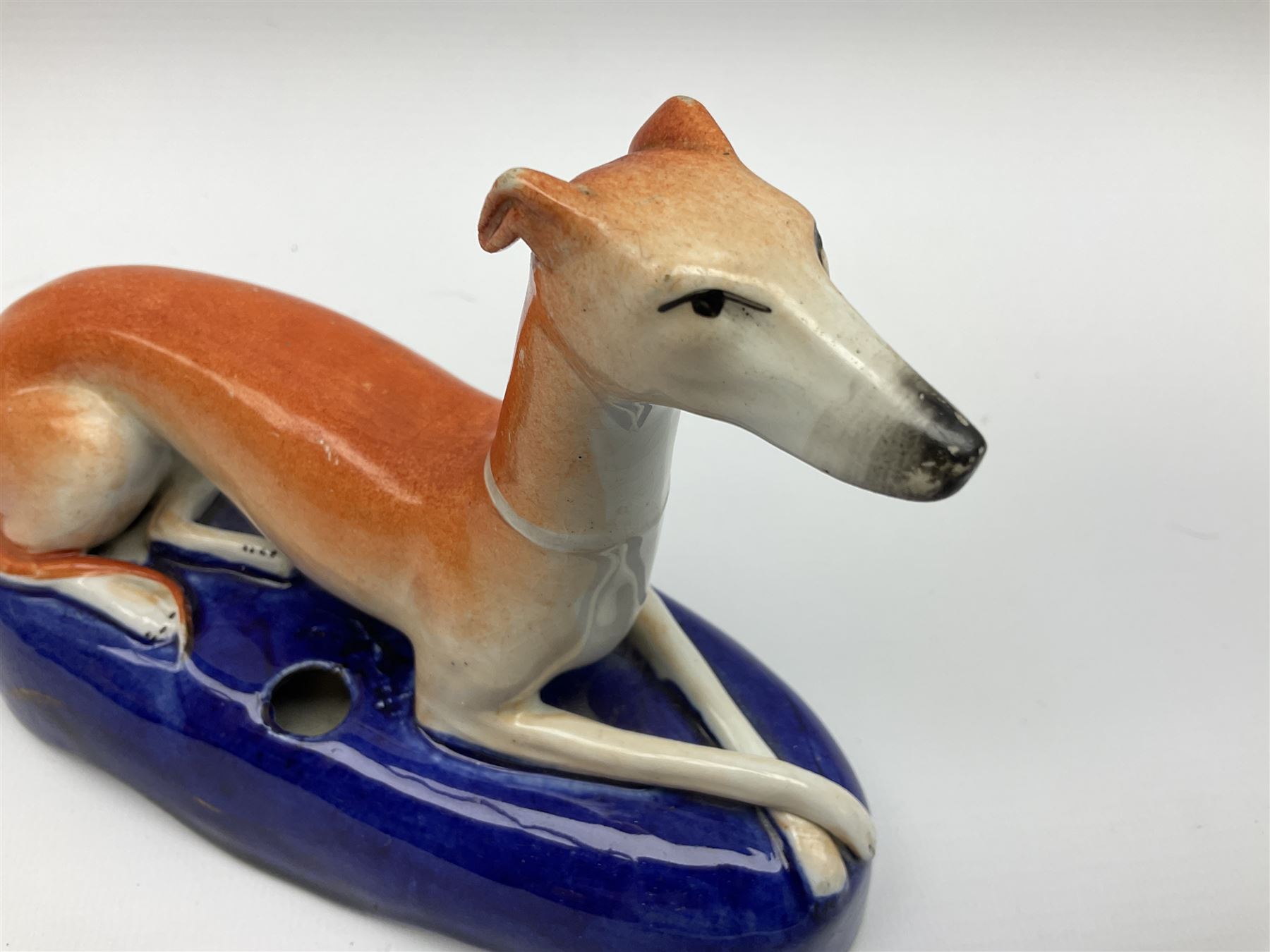 Pair of Staffordshire recumbent greyhound pen holders 