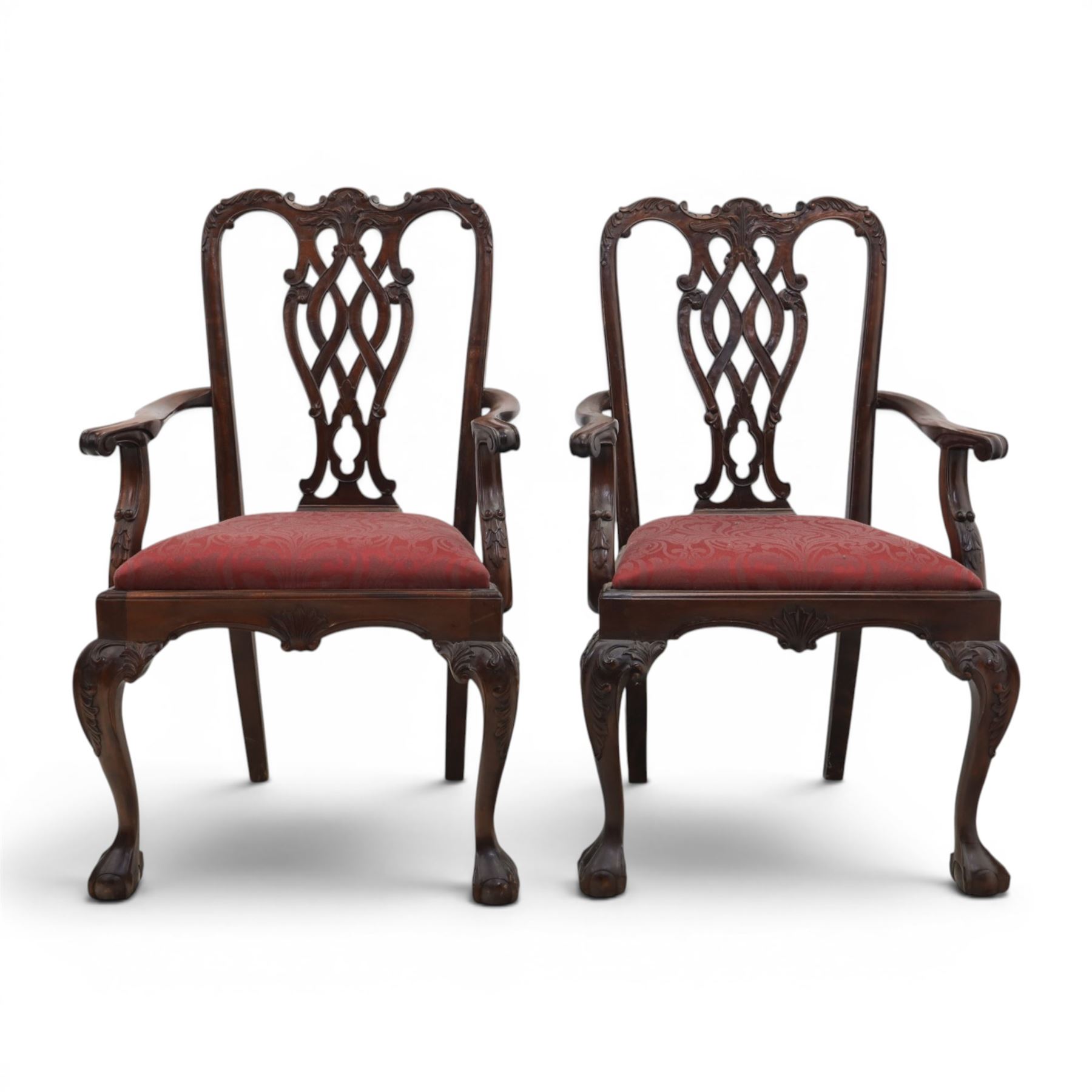 Chippendale design set of ten (8+2) mahogany dining chairs, serpentine cresting rails with carved detail over pierced ribbon-tied splats, red damask upholstered drop-in seats, on cabriole supports with acanthus carved knees and claw and ball feet