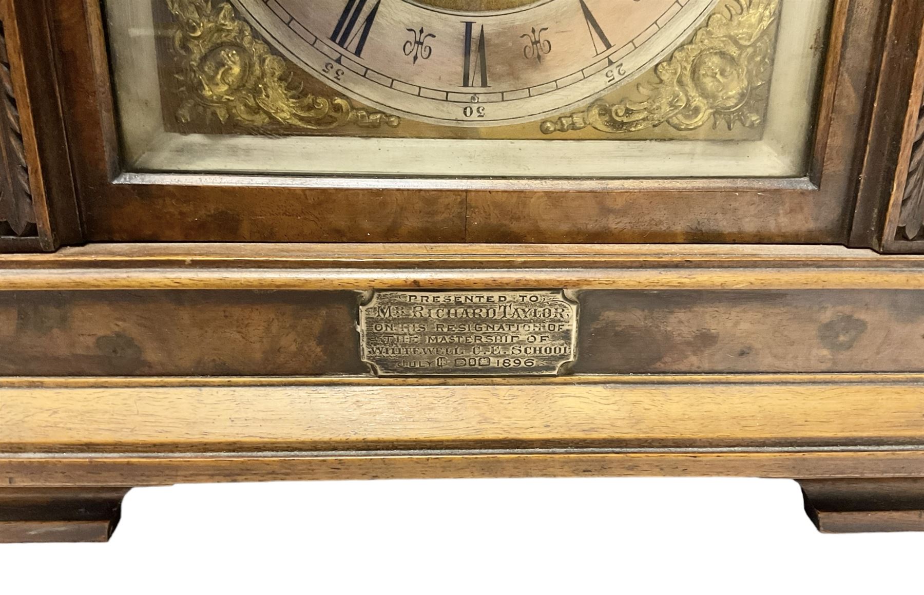 Lenzkirch - Late 19th century 8-day German mantle clock in a walnut veneered case with an architectural pediment, square brass dial, cast spandrels, matted dial centre, silvered chapter ring and fleur-di-Lis hands, with a twin train movement chiming the quarters on two coiled gongs and striking the hours on one. With Key and pendulum. Silver presentation plaque dated 1896.