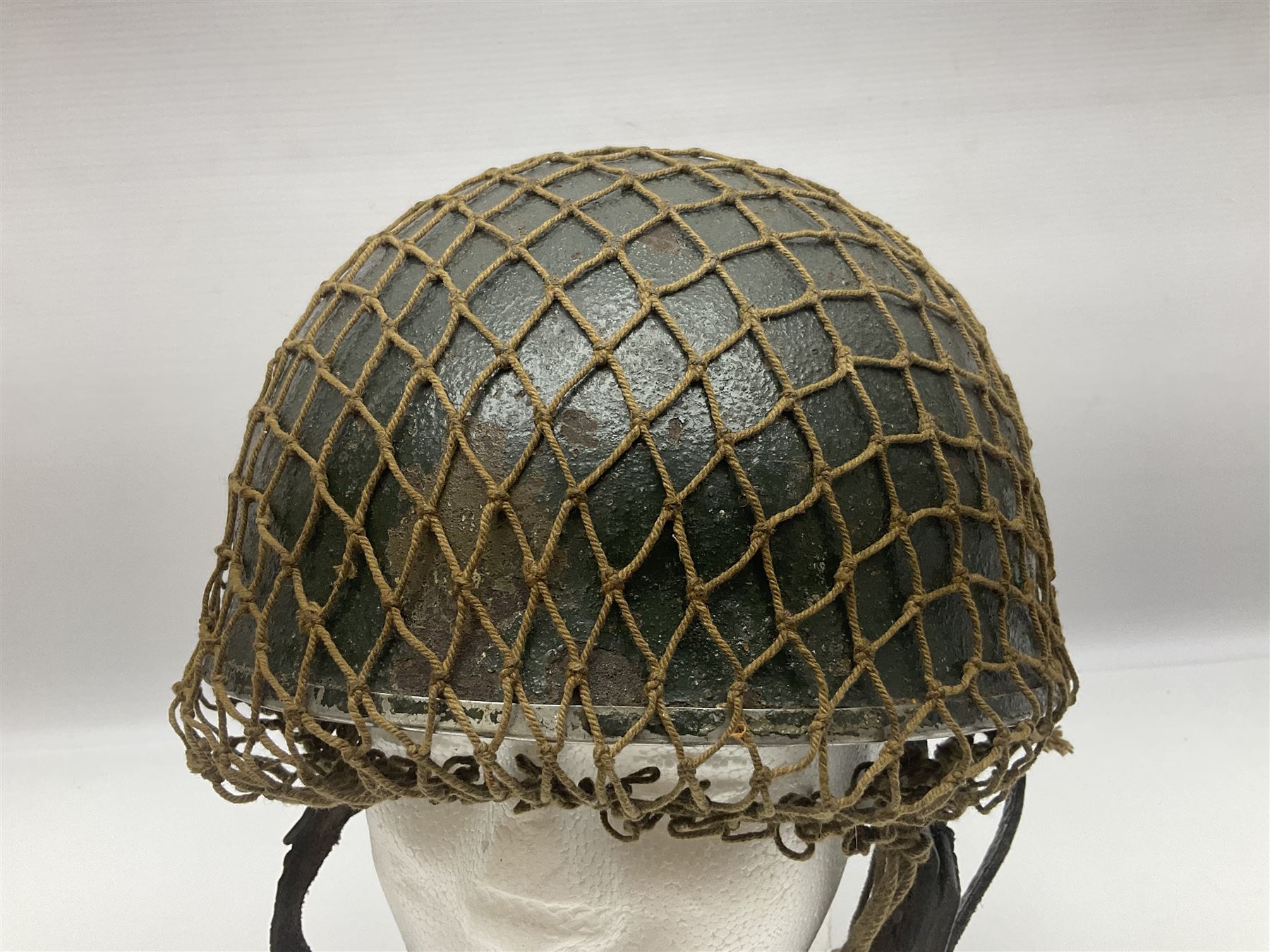 WW2 British Airborne Troops/Paratroopers Steel Helmet with green textured paint finish and netting cover, leather and sponge liner and three point chinstrap mounting; liner marked BMB 1943; together with a paratrooper's maroon beret with metal badge (2)