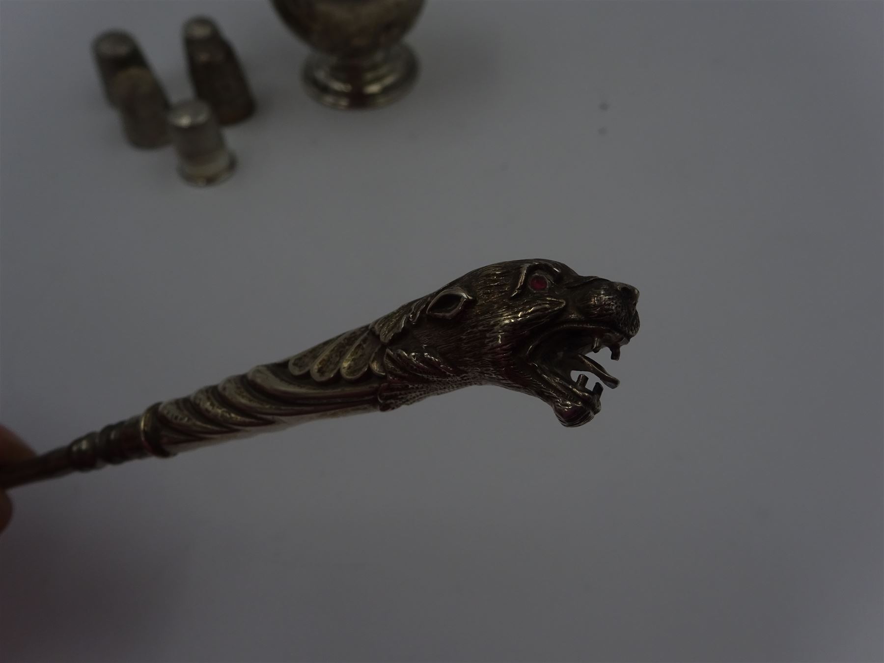 Group of silver sewing accessories, to include button hook, with silver leopard's head handle, hallmarks worn and indistinct, an Edwardian silver pin cushion, with embossed rose decoration and removable beaded pin cushion, hallmarked Charles Boyton & Son Ltd, London 1905 and five silver thimbles, including one continental silver example, all stamped or hallmarked 