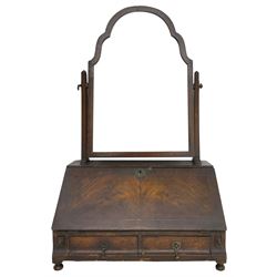 George I design walnut table mirror, the swing mirror in a cusped arch frame supported by two tapered horns, sloping fall front with matched veneers enclosing ebonised interior with three divisions over two small drawers with shaped facias, fitted with two drawers, on turned feet