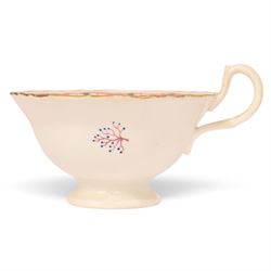 Late 19th century tea service, decorated with a green and pink strips, with internal decoration of budding branch within a gilt band upon a white glazed ground, comprising  twin handle lidded sucrier, milk jug, three serving plates, nine cups and saucers and four teacups