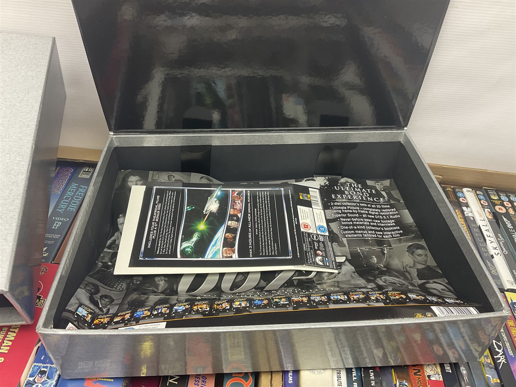 Large collection of VHS tapes, DVDS, CDs to include Queen, James Bond 007, Batman etc, in three boxes