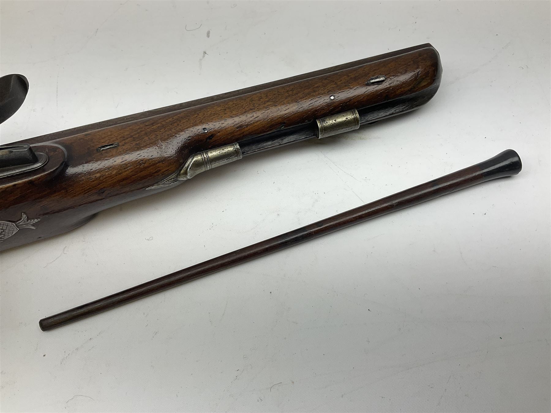 Early 19th century flintlock 16-bore overcoat/duelling pistol by William Bond Lombard Street London, the 23cm octagonal brown stub twist damascus barrel with small foresight, two barrel pins and ram rod under, inscribed Lombard Street London to the top and W. Bond to the action, full walnut stock with lightly engraved steel furniture, pineapple finial and escutcheon, half cock facility L39cm; loose mounted on later mahogany display stand with trade label