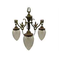 Early 20th century brass chandelier, central flute with three projecting scrolled branches decorated with foliage, fitted with three cut glass shades 