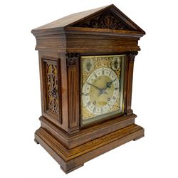 Winterhalder & Hofmeier- German 8-day oak cased mantle clock, in an architectural styled case with a gable pediment and recessed carving to the tympanum, square brass dial flanked by carved reeded pilasters and capitals, with open carved silk backed sound frets on a shaped plinth with padded feet, brass dial with cast spandrels and silvered chapter, Roman numerals, minute track and stylised gothic hands, conforming chime/silent and pendulum regulation dials, twin train going barrel movement with quarter-hour striking on two coiled gongs and the hours on one.
With pendulum.