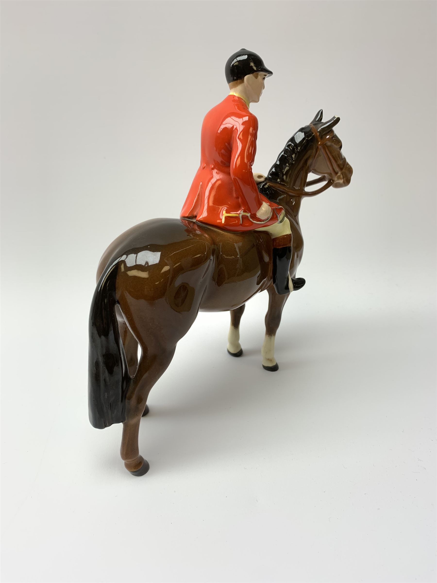 A Beswick equestrian figure modelled as a huntsman on bay horse, with printed mark beneath, together with a Beswick Norman Thelwell figure of a pony and rider, with printed mark beneath  