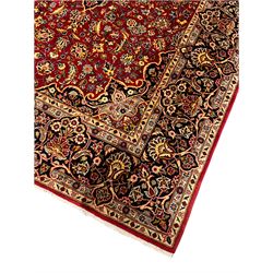 Persian red ground Kashan rug, all over floral design with interlaced foliate and stylised flower heads, repeating scrolled border with plant motifs