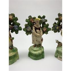 Pair of 19th century Staffordshire figures, modelled as 'Sheperd' and 'Sheperdess', each stood before bocage and accompanied by dog, upon titled bases, largest H14cm, together with a further similar example, the base inscribed 'Sheperd' 