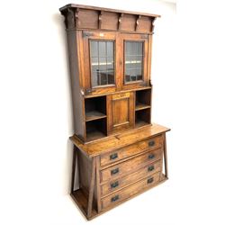 Arts & Crafts oak cabinet on chest, projecting cornice above to lead glazed cabinet doors, two shelves flanking single fall front enclosing fitted interior, four graduating drawers