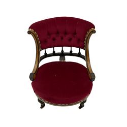 Victorian ebonised and amboyna nursing chair, the curved serpentine upright supports joined by balustrade, upholstered seat and buttoned back in claret fabric, turned and fluted supports with ceramic castors 