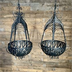 Pair of black finish wrought metal hanging baskets, with brackets