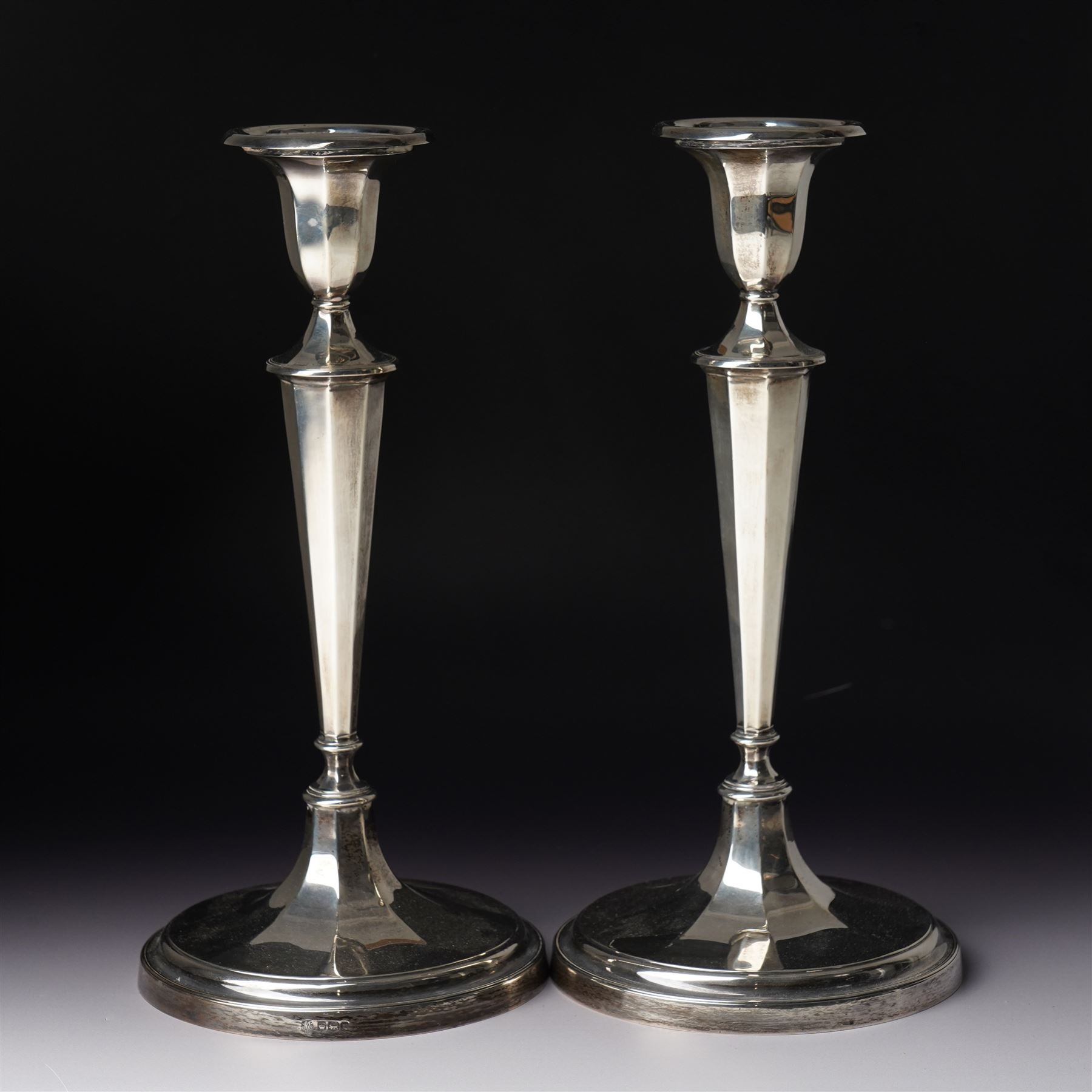 Pair of silver candlesticks with octagonal tapering stems and circular weighted bases H30cm Sheffield 1923 Maker Hawksworth Eyre & Co Ltd