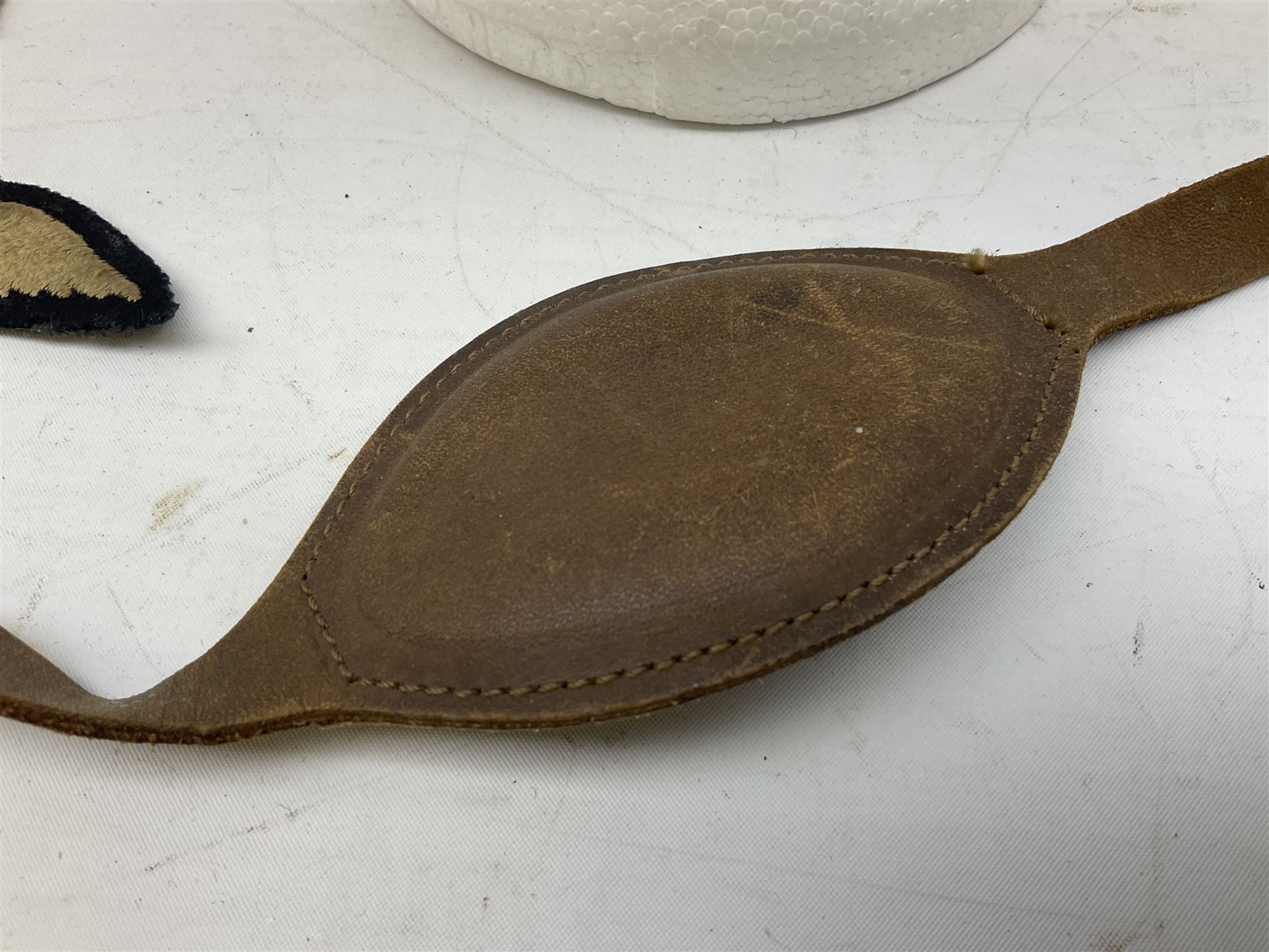 WW2 RAF sidecap dated 1942 with badge and buttons; quantity of RAF metal and cloth badges, pips and buttons; and paratrooper's helmet chin strap