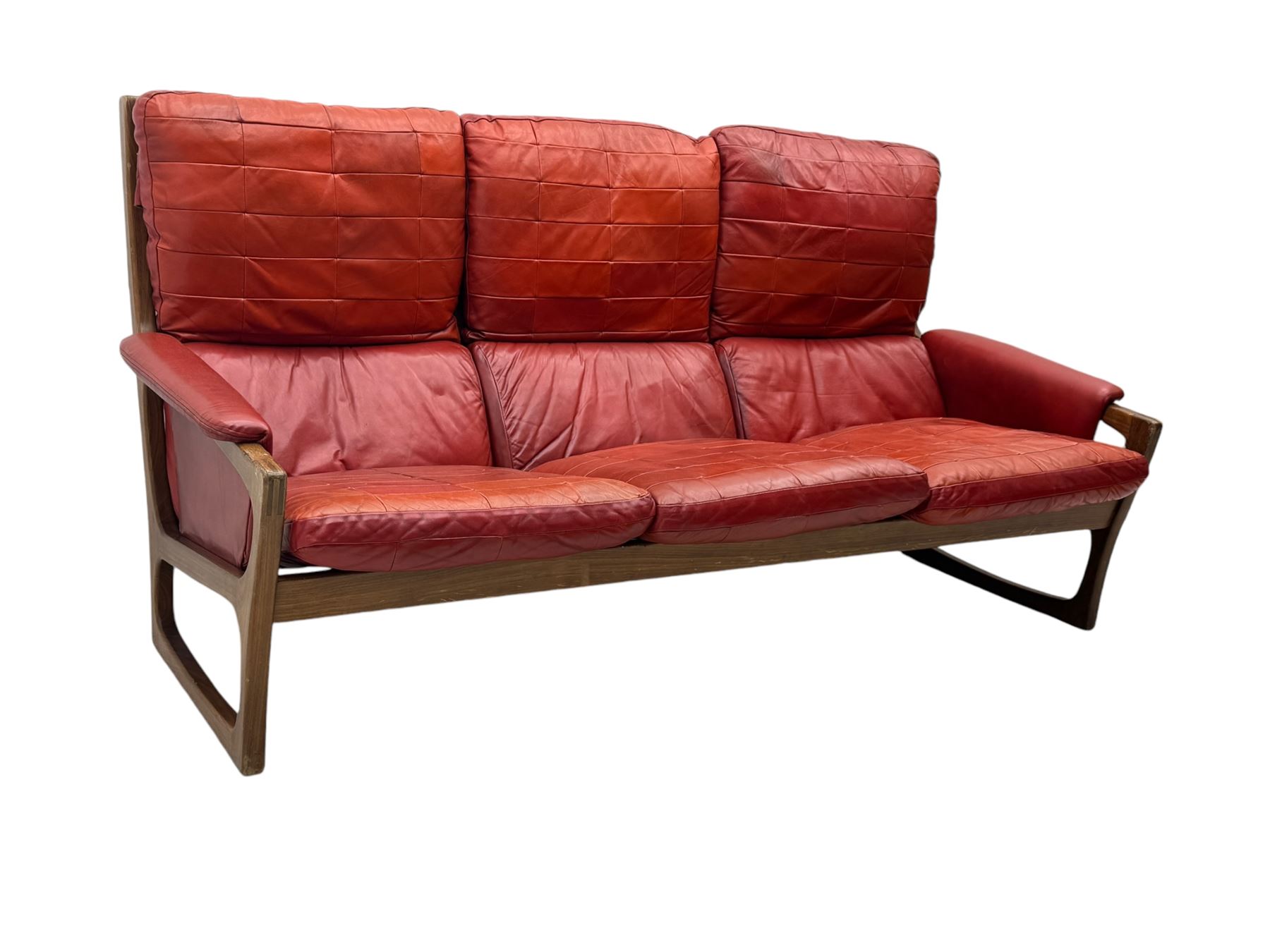 Folke Ohlsson for Gimson & Slater - mid-20th century Danish teak-framed sofa, red leather upholstery with patchwork design, raised on shaped teak side supports