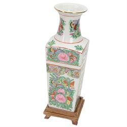 20th century Chinese sang de boeuf vase of baluster form with elephant head handles, togehter with a pair of famille rose vases decorated with floral decoration and insects, upon wooden stands   