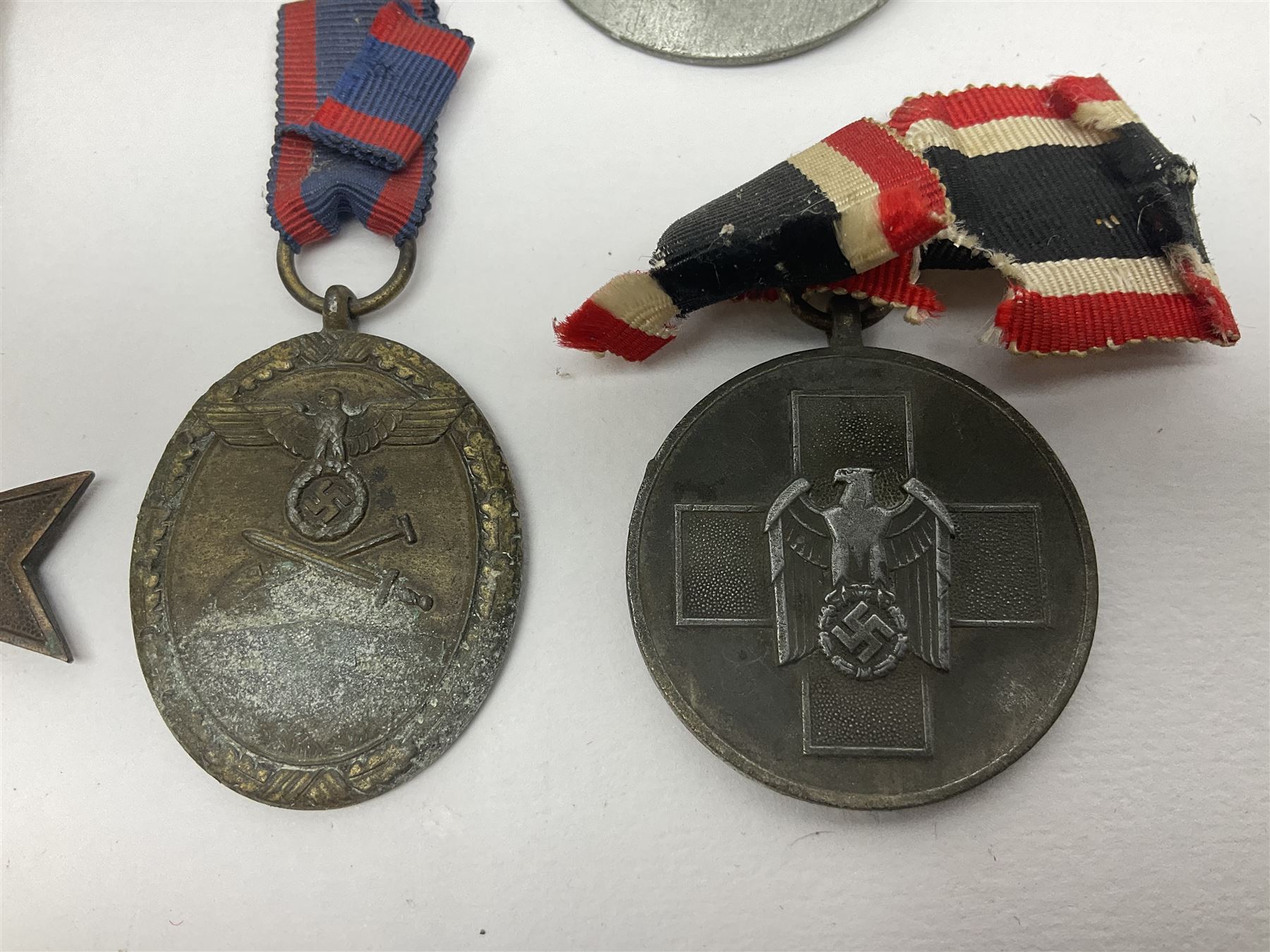 Five WW2 German medals/badges -German Defences West Wall Medal, War merit Cross, Red Cross Decoration, RAD tinnie brooch and Adolf Hitler 1934 medallion (5)