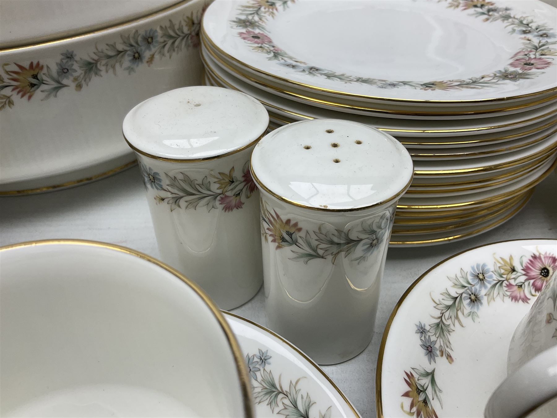 Royal Albert Paragon tea and dinner service for twelve decorated in the Belinda pattern, comprising fourteen saucers, twelve teacups, thirteen side plates, teapot, sauce boat and stand, salt and pepper shakers, two jugs, sucrier, twelve dinner plates, twelve smaller plates, two lidded tureens, twelve bowls, twelve smaller bowls, cake plate, oval plate and oval dish (100)