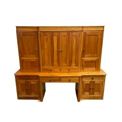 Large contemporary cherry wood break-front wall unit, the banded cornice over double cupboard with bifold doors and two drawers, flanked by four single cupboards, the base fitted with four drawers over four cupboards (W263cm, H216cm, D68cm); and a cherry wood cabinet, fitted with double cupboard over two short and two long drawers, with faux drawer facias (W81cm, H138cm, D66cm)