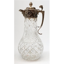 Elizabeth II silver mounted cut glass claret jug, the clear glass body of baluster form with hobnail and diamond cut decoration, leading to a silver mount with chased decoration depicting putti within scrolling detail, mask detailed spout, dragon capped scroll handle, and hinged cover with bud finial, hallmarked B P Co, London 1978, H29.5cm
