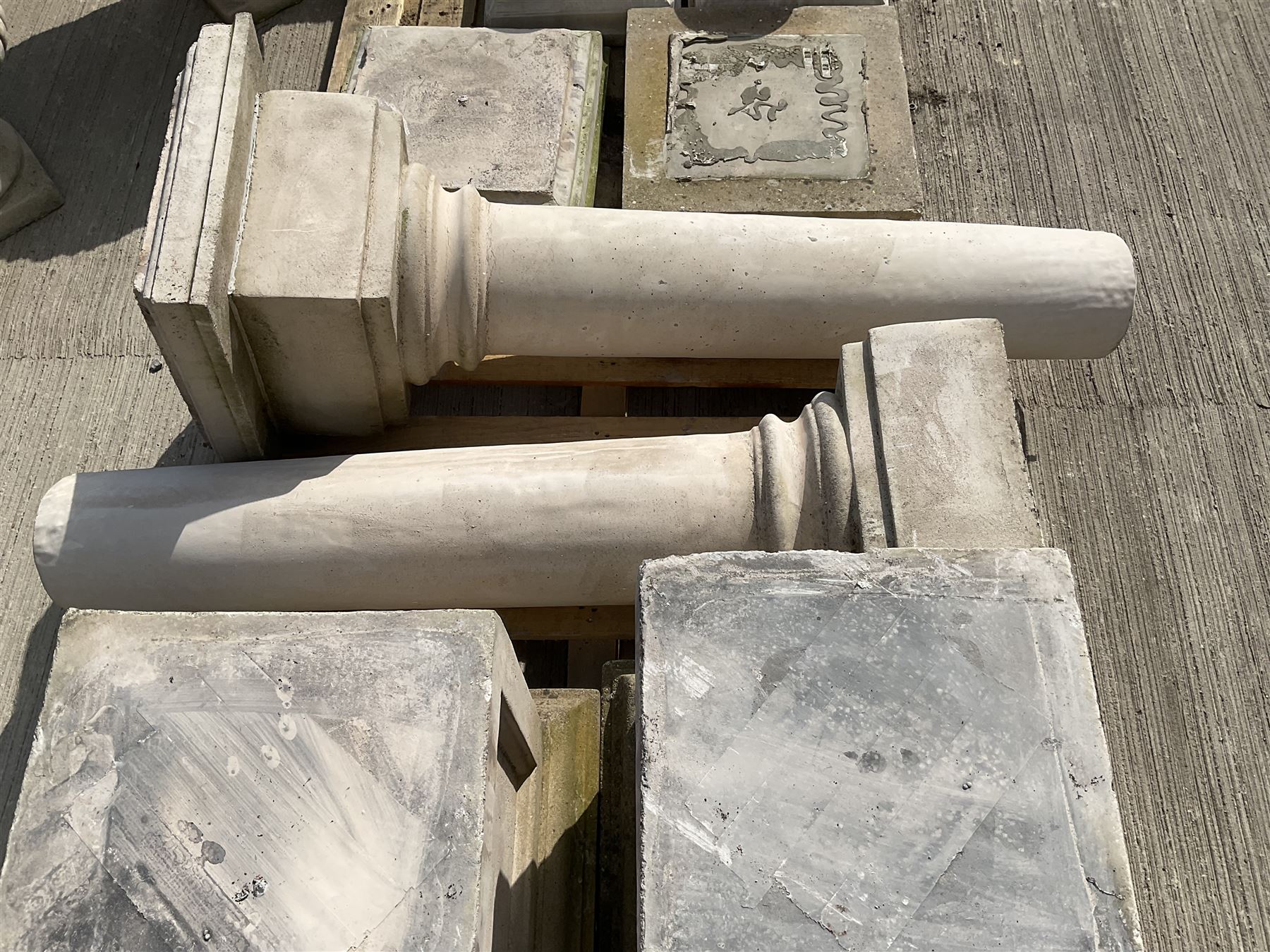 Set of four cast stone architectural columns, tapering form, on square plinth bases