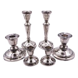 Pair of modern silver mounted candlesticks, hallmarked Birmingham 1993, makers mark W W, H14.5cm, together with an early 20th century pair of silver mounted dwarf candlesticks, hallmarked Chester 1911, makers marks worn and indistinct, H7.5cm, and a similar smaller modern pair of silver mounted dwarf candlesticks, hallmarked Birmingham 1986, makers mark W W, H5.5cm, all with filled bases